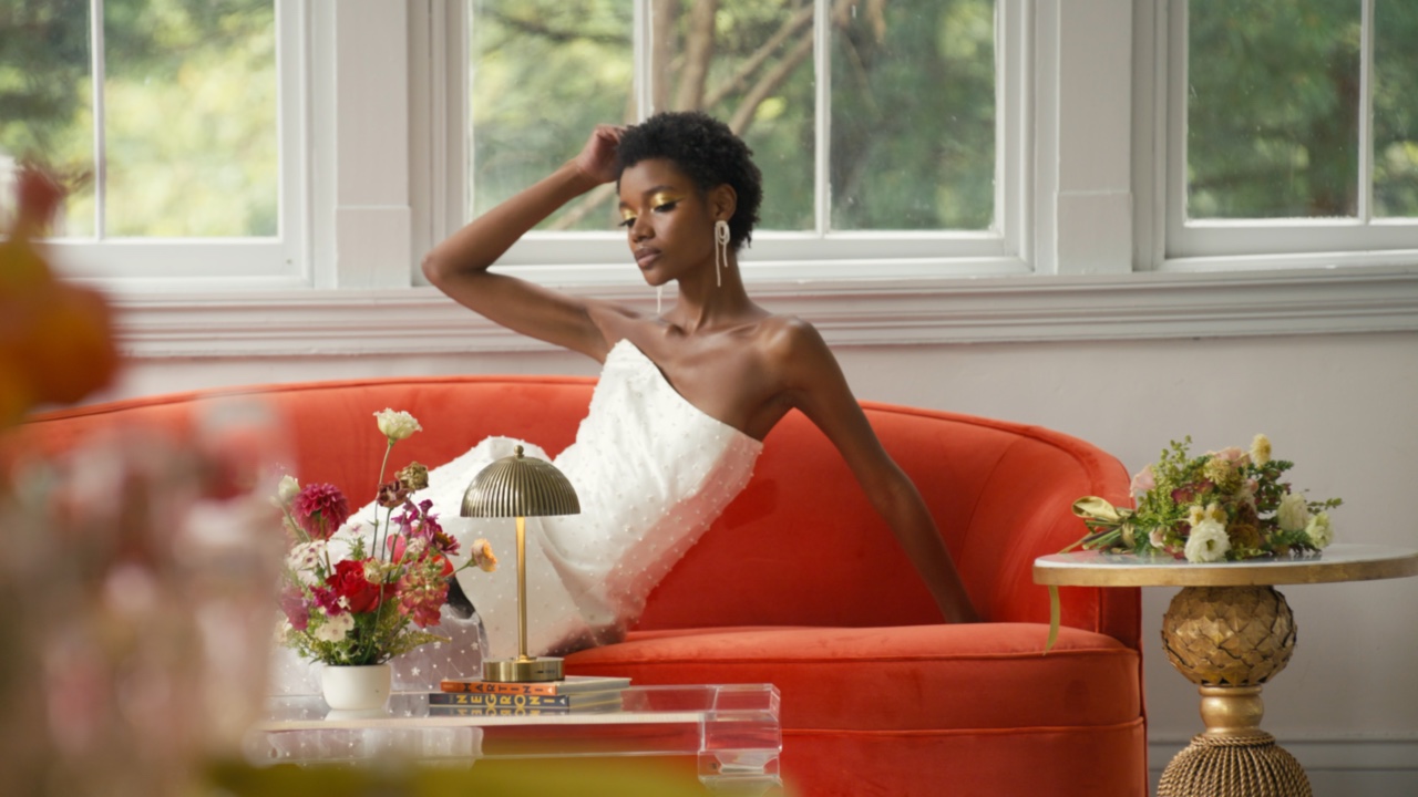A model seated in the completed red, chartreuse, and floral environment